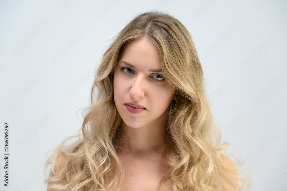 A large photo portrait of a pretty model with long hair and a beautiful hairstyle on a white background.