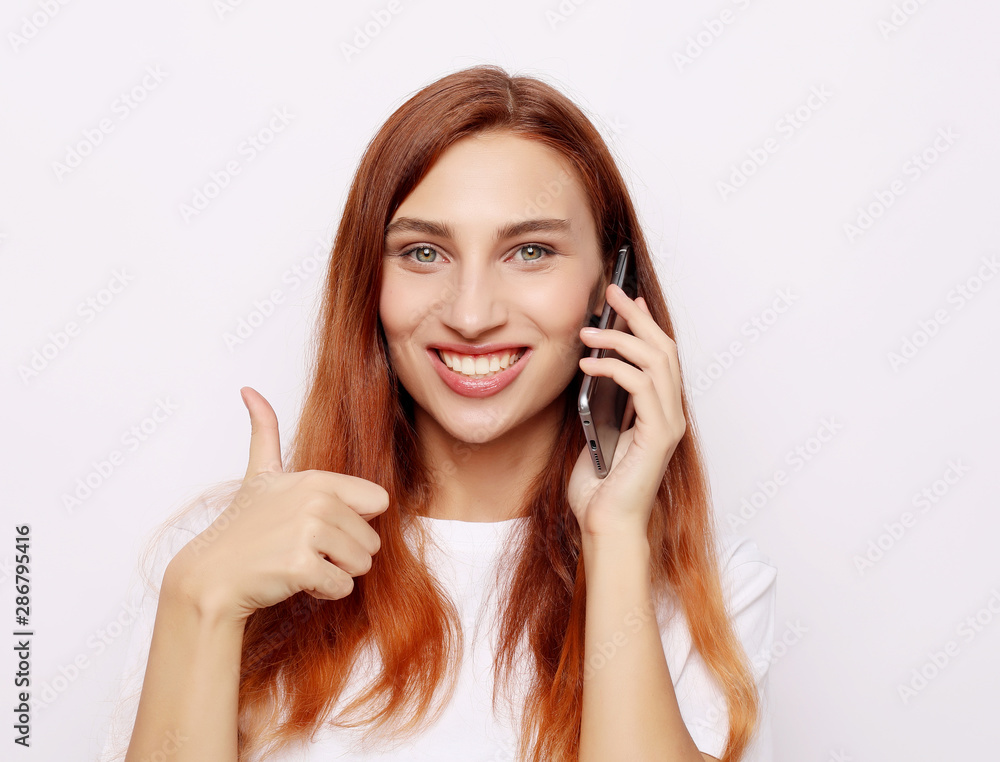 Happy young caucasian female making thumb up sign and smiling cheerfully, showing her support and respect to someone. Happy young caucasian female making thumb up sign and smiling cheerfully, showing her support and respect to someone.