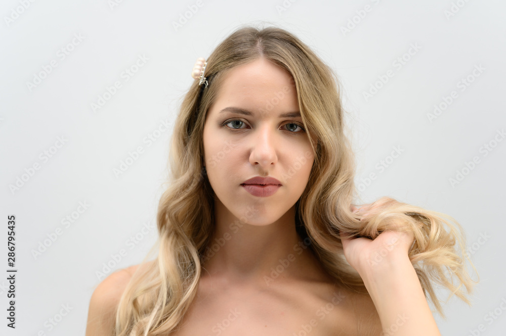A large photo portrait of a pretty model with long hair and a beautiful hairstyle on a white background. A large photo portrait of a pretty model with long hair and a beautiful hairstyle on a white background.