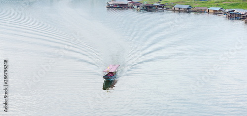 View of the life of villagers sailing on a large dam near the waterfront community at Khao Laem Dam, Sangkhla Buri District photo