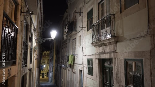 Old and typical street with balconies and lantern at night photo