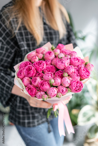 Pink and purple roses . Beautiful bouquet of mixed flowers in woman hand. Floral shop concept . Handsome fresh bouquet. Flowers delivery.