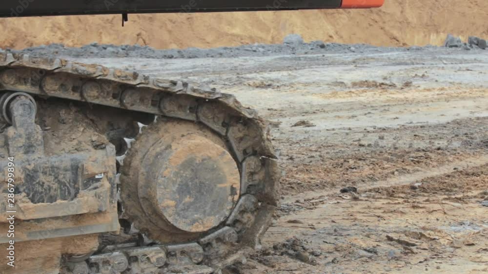 Closeup caterpillar of an excavator rides. Digs coal on a open pit Closeup caterpillar of an excavator rides. Digs coal on a open pit