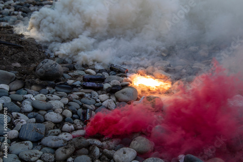 A number of smoke bombs laying on the rocky ground.