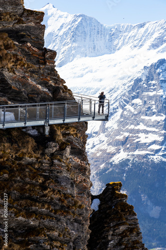 Traveller are walking on sky cliff walk at First peak of Alps mountain , Grindelwald Switzerland photo