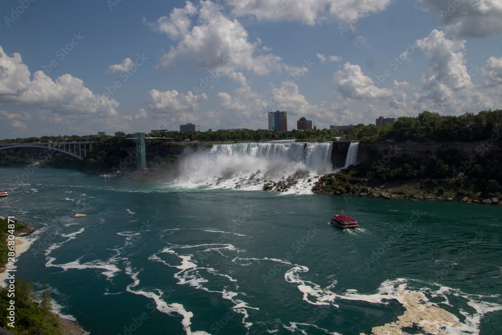 A view of Niagara falls with a boat filled with people