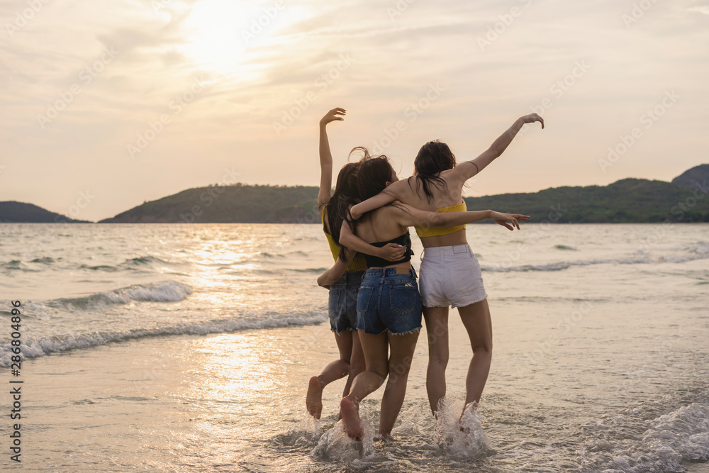 Group of three Asian young women running on beach, friends happy relax having fun playing on beach near sea when sunset in evening. Lifestyle friends travel holiday vacation on beach summer concept.