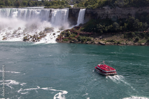 A view of Niagara falls with a boat filled with people