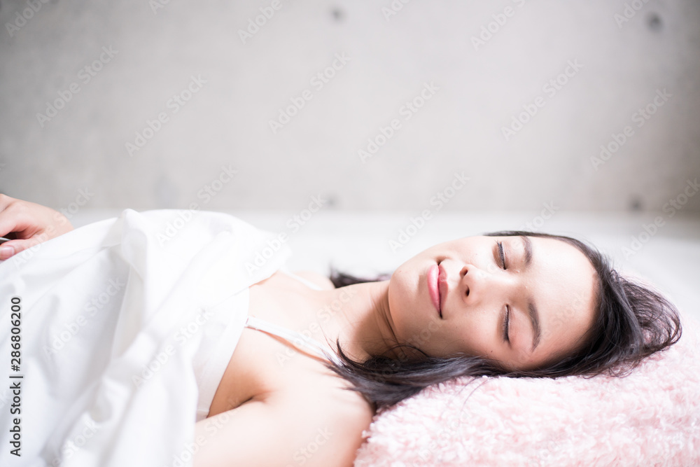 Naklejka premium Young woman sleeping on bed