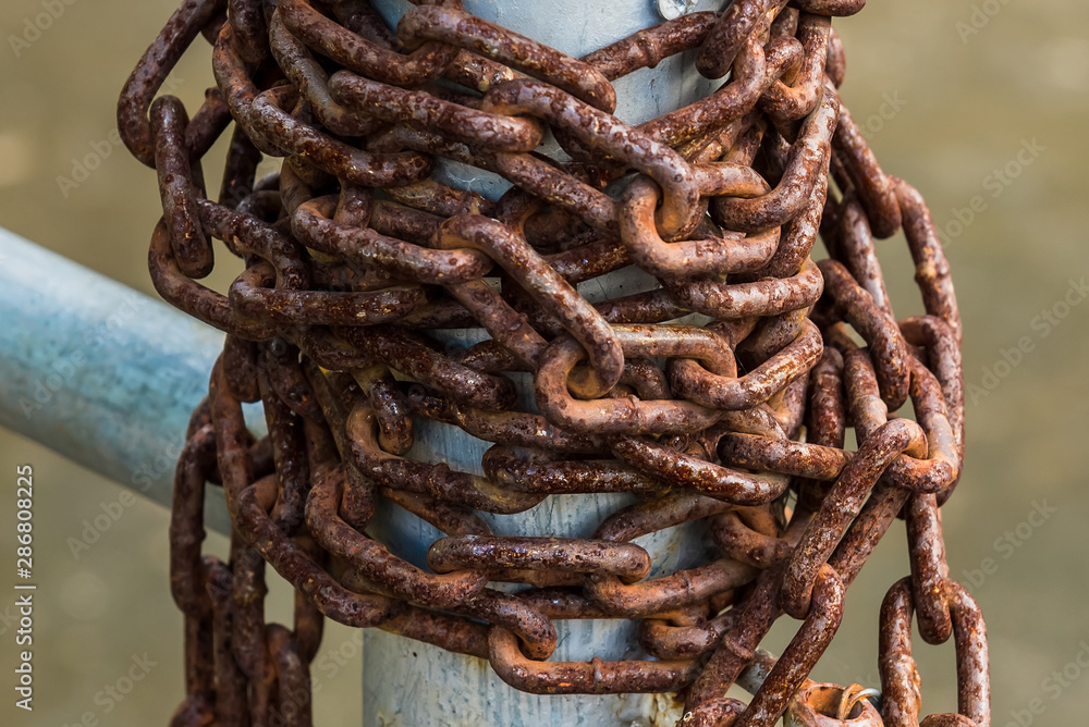 Old rusty chains on a steel pole. Old rusty chains on a steel pole.
