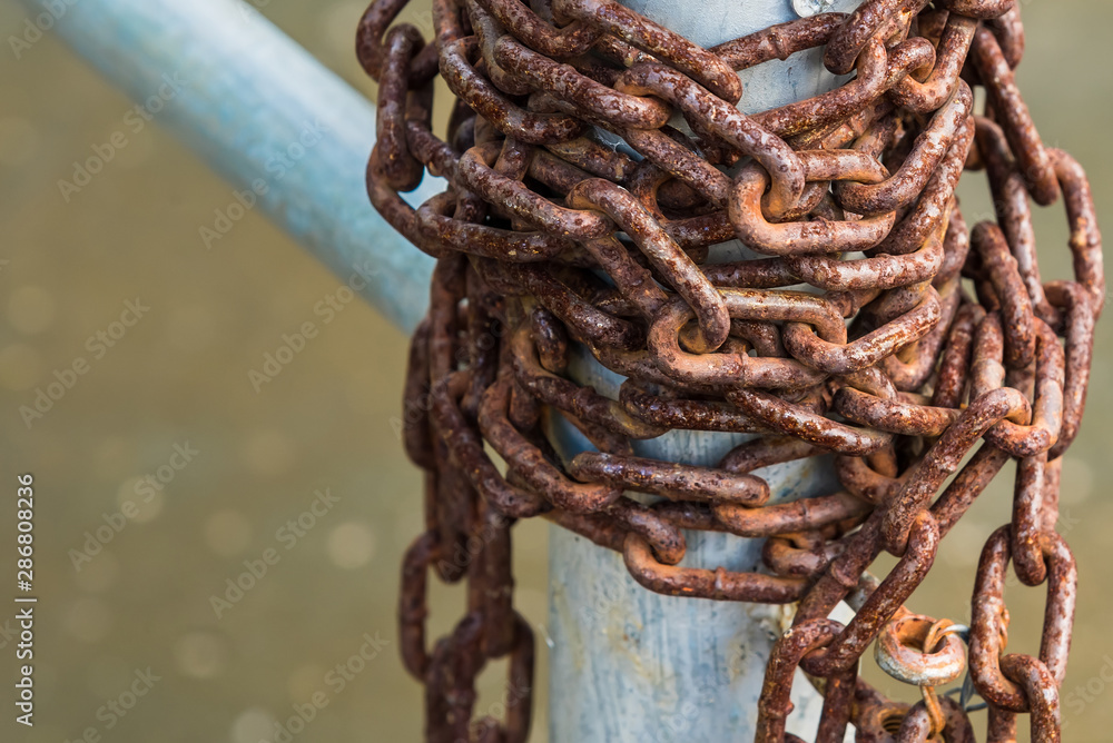 Old rusty chains on a steel pole. Old rusty chains on a steel pole.