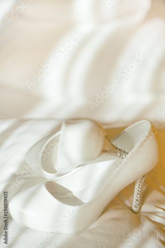 Delicate wedding shoes waiting for the bride