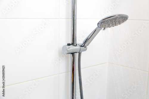  Chrome shower on white tile.Horizontally, Vertically.