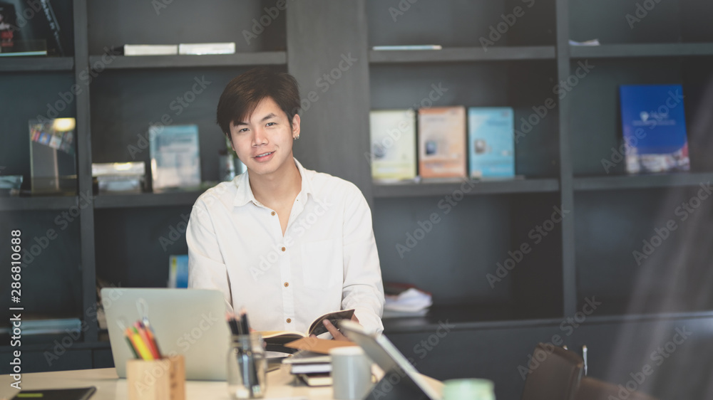 Cheerful young male freelancer smiling to the camera