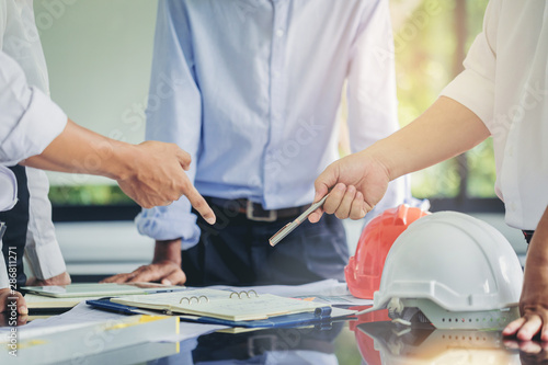 Contractor and engineer with blueprints discuss at a modern construction site, Engineers in mechanical factory reading instructions