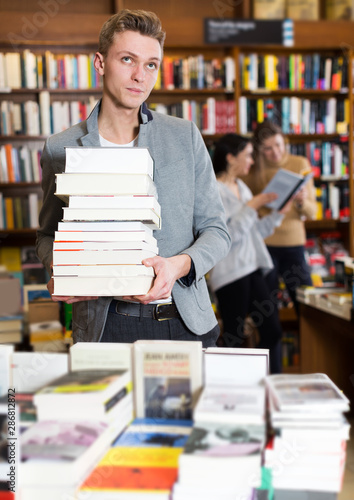 Tired student standing with pile of books