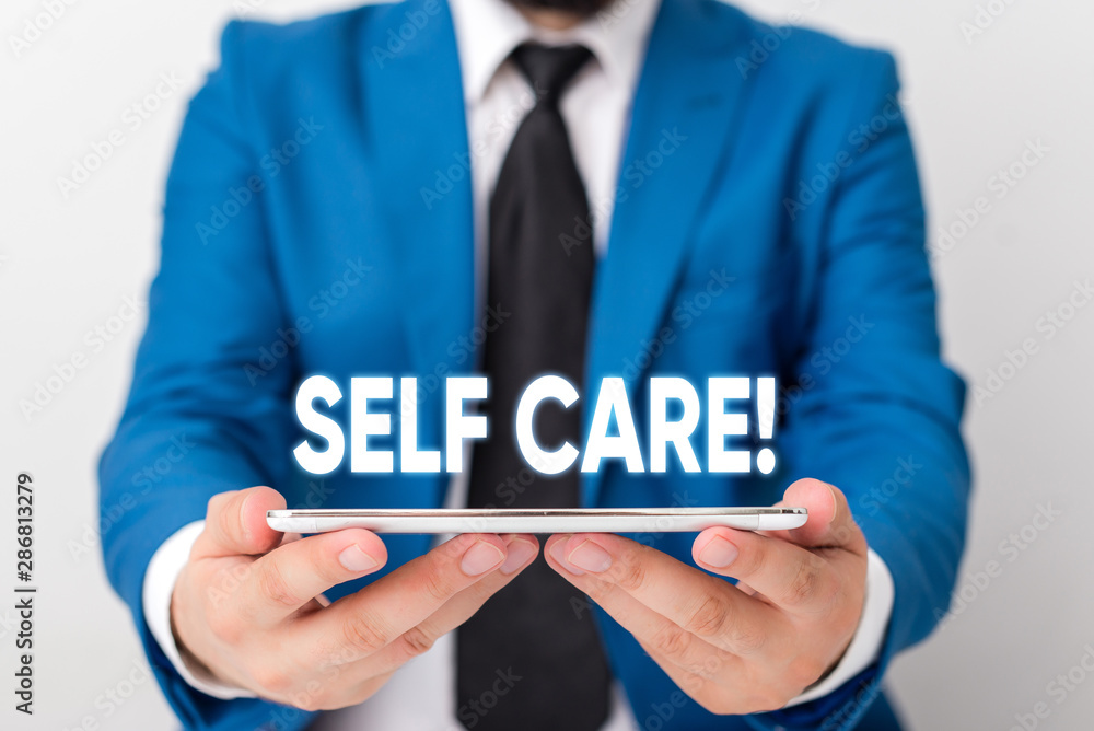 Handwriting text writing Self Care. Conceptual photo practice of taking action to preserve or improve ones own health Businessman in blue suite with a tie holds lap top in hands Handwriting text writing Self Care. Conceptual photo practice of taking action to preserve or improve ones own health Businessman in blue suite with a tie holds lap top in hands