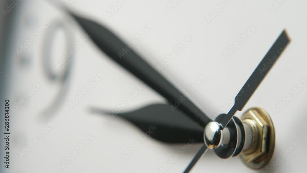 White clock face with three narrow black hands showing nine minutes to nine White clock face with three narrow black hands showing nine minutes to nine
