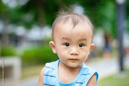 Portrait of little adorable Asian baby boy in park