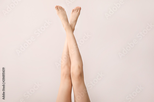 Legs of beautiful young woman on light background