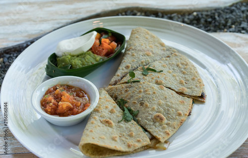 Vegan tortilla wrap, with vegetabes on a wooden background