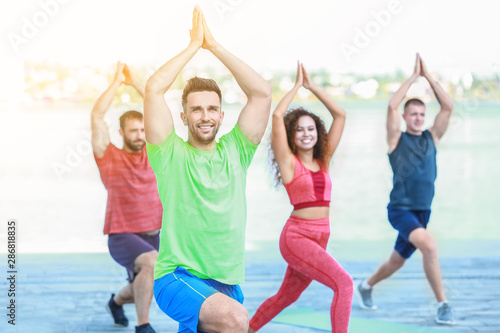 Group of young sporty people training together outdoors