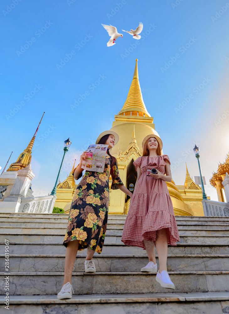 Naklejka premium young tourist women walking through the palace temple in Bangkok of Thailand, Emerald Buddha Temple, Wat Phra Kaew, Bangkok Royal Palace popular tourist place
