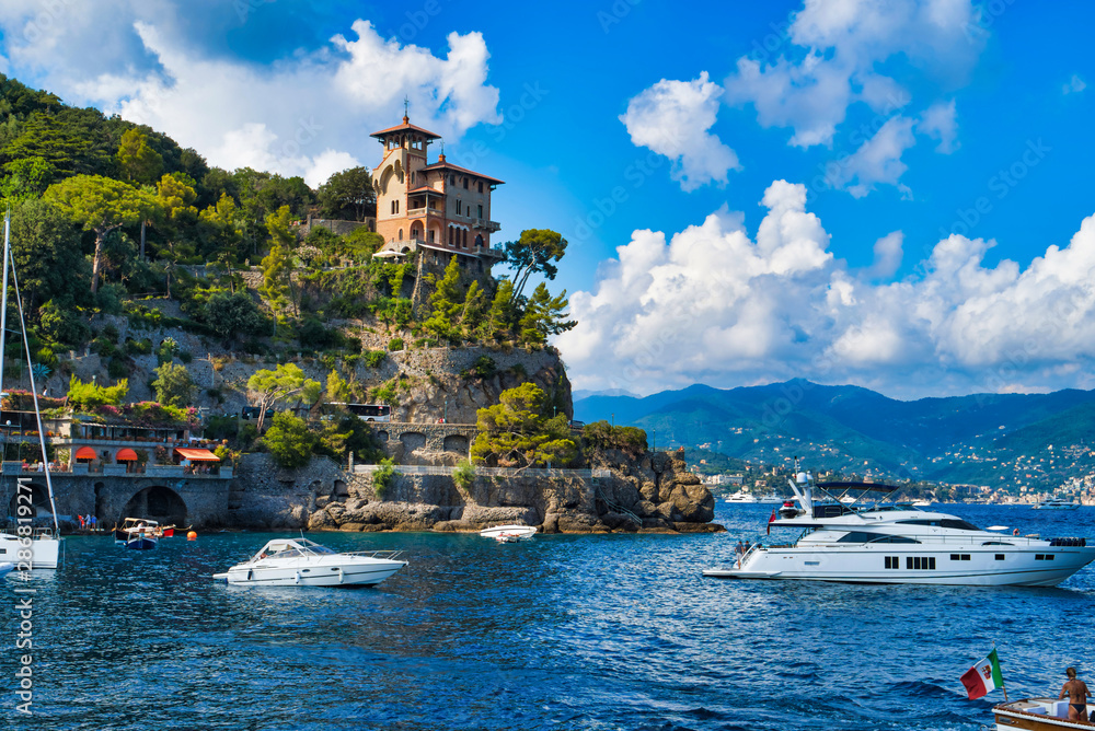 Naklejka premium Portofino, Italy - AUGUST 15, 2019: Portofino harbor, yachts and water boats, cliff building / popular European resort / Italian Riviera