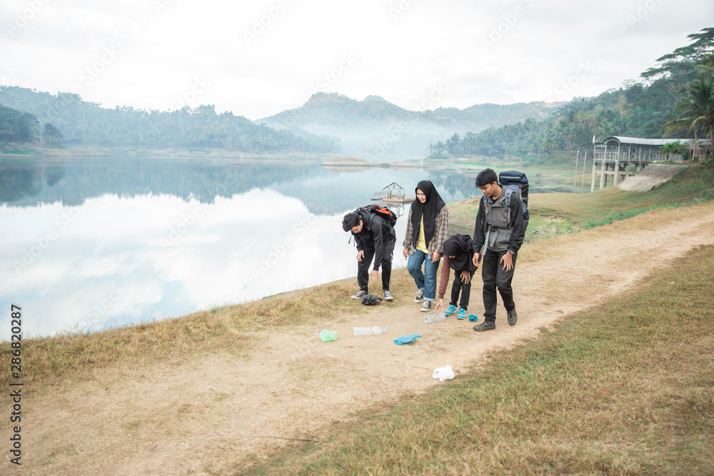group of hikers picking up trash while camping