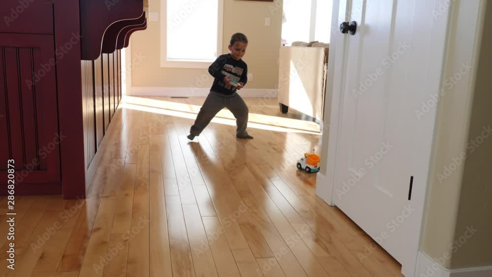 A cute little boy plays with his toy remote control car in his house A cute little boy plays with his toy remote control car in his house