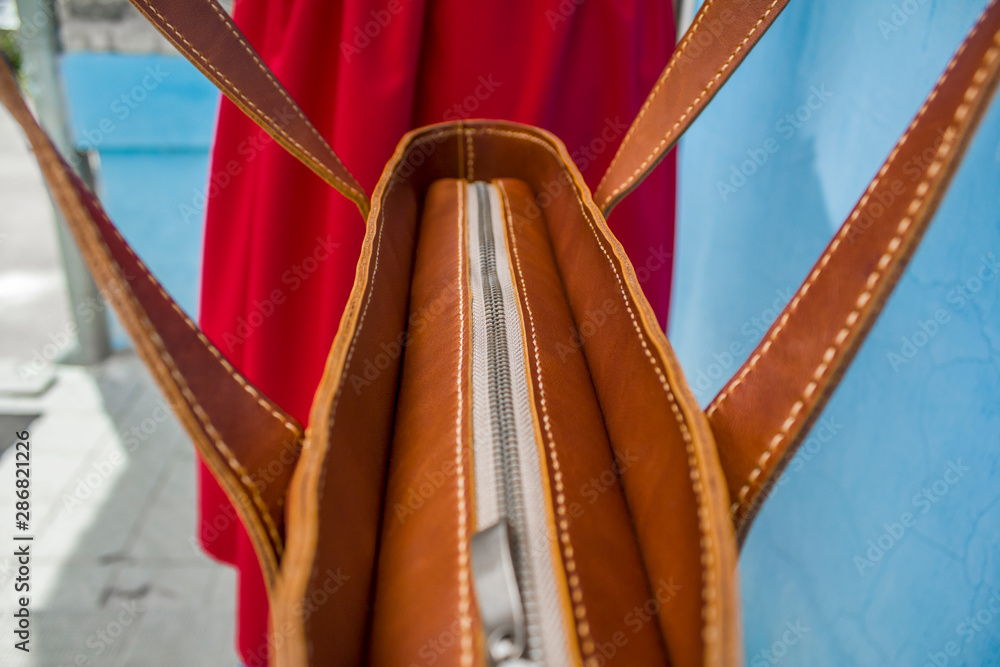 Obraz premium metal zipper close-up on the background of a blurred bag and a red dress