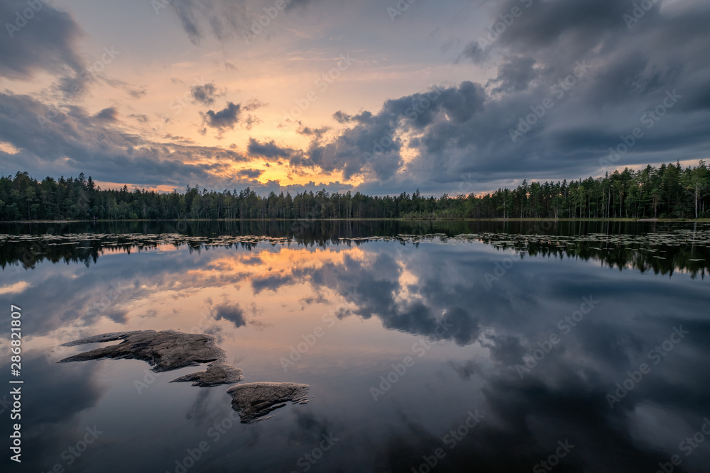Scenic lake landscape with tranquility mood, sunset and beautiful reflections at summer evening in Finland