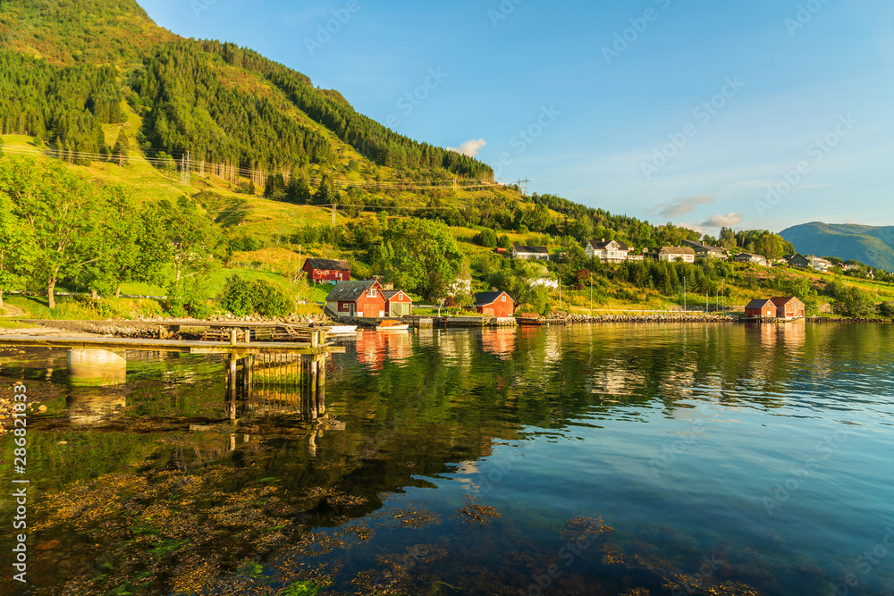 Fototapeta premium Rural houses in Norwegian fjords green landscape, Norway, Rosendal village.