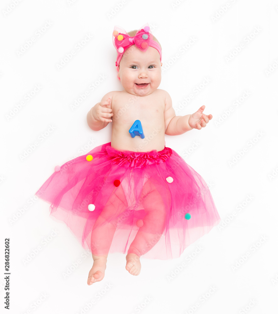Portrait of a sweet infant wearing a pink tutu and headband bow, isolated on white in studio