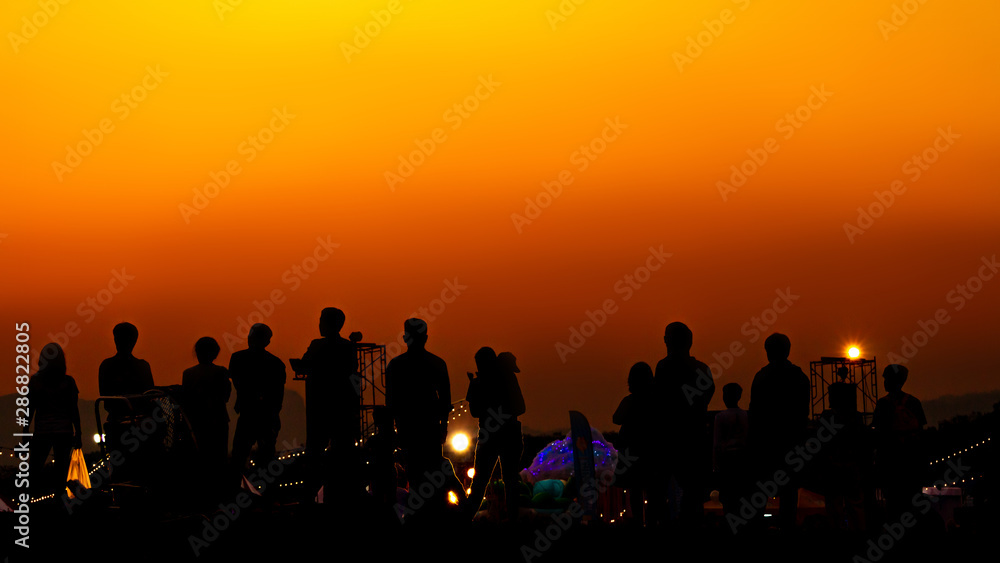 Silhouette of many tourists are taking pictures by smart phone on the top of the mountain during sunset times. Silhouette of many tourists are taking pictures by smart phone on the top of the mountain during sunset times.
