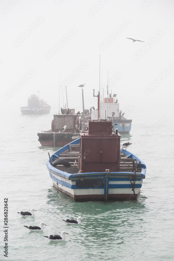 Fishing boats anchored in the fog