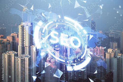 SEO hologram on city view with skyscrapers background double exposure. Search optimization concept.