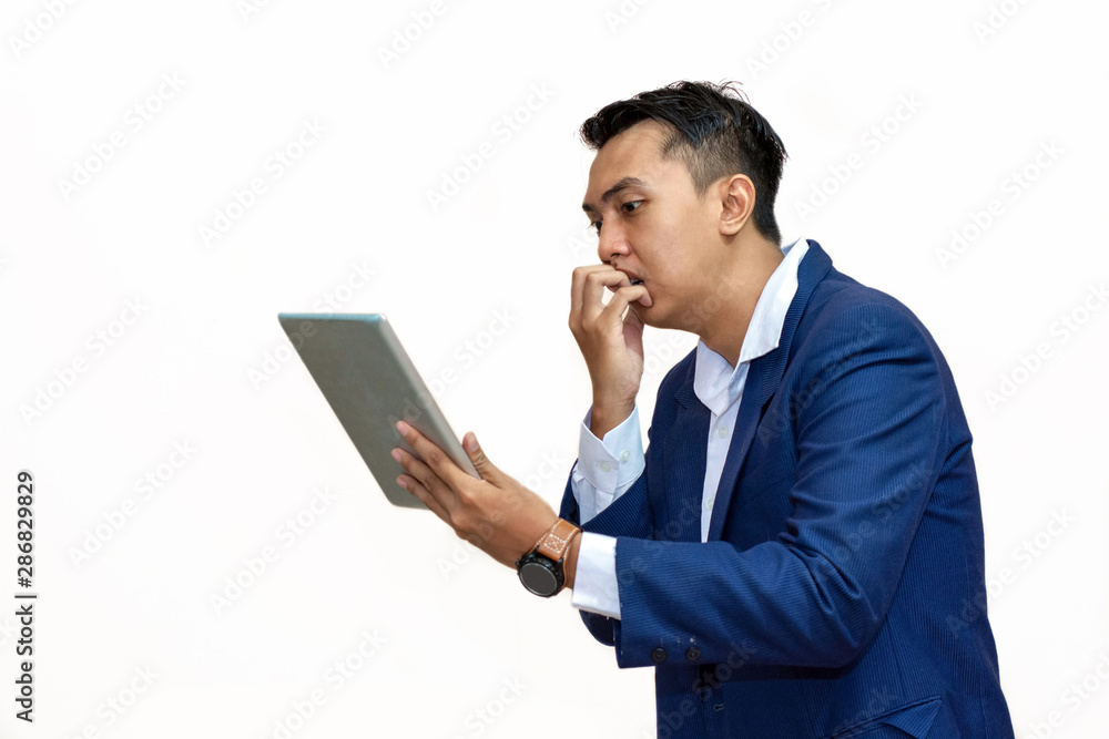 young asian business man looking worried while reading something on his electronic pad young asian business man looking worried while reading something on his electronic pad