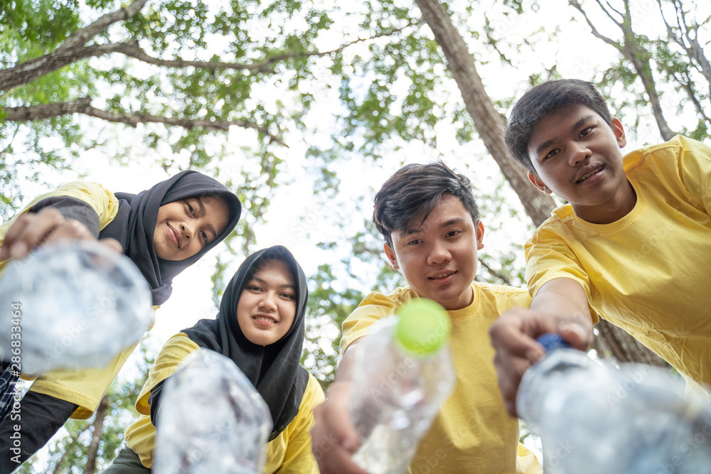 Group of asian teenage volunteers pick up bottle trash at the park Group of asian teenage volunteers pick up bottle trash at the park