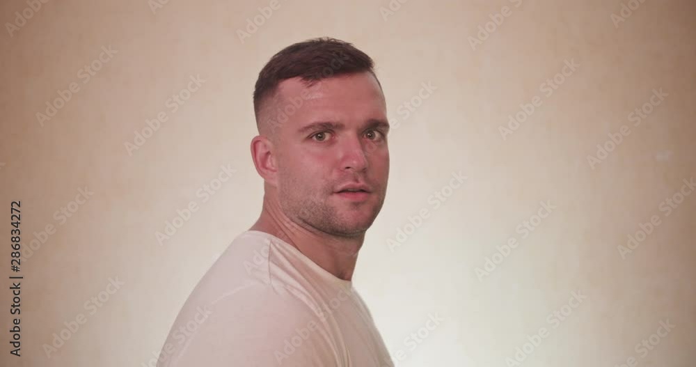 Portrait og handsome man turn on camera side and acting emotions and smiling , surprized face mimics . Fun concept with lught background Portrait og handsome man turn on camera side and acting emotions and smiling , surprized face mimics . Fun concept with lught background