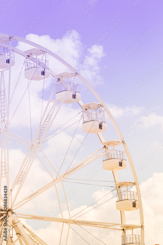 Ferris wheel on the colorful cloudy sky. Background concept of happy holidays time. Ferris wheel on the colorful cloudy sky. Background concept of happy holidays time.