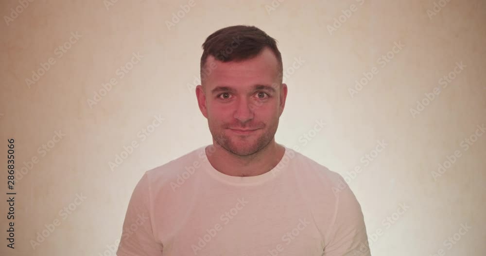 Portrait og handsome man turn on camera side and acting emotions and smiling , surprized face mimics . Fun concept with lught background Portrait og handsome man turn on camera side and acting emotions and smiling , surprized face mimics . Fun concept with lught background