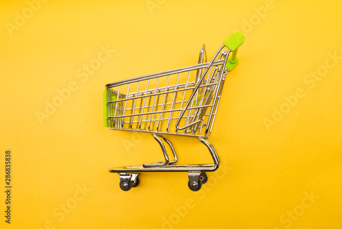 supermarket trolley on yellow background