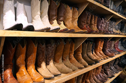 Cowboy boots on sale on a shelf in the store indoors