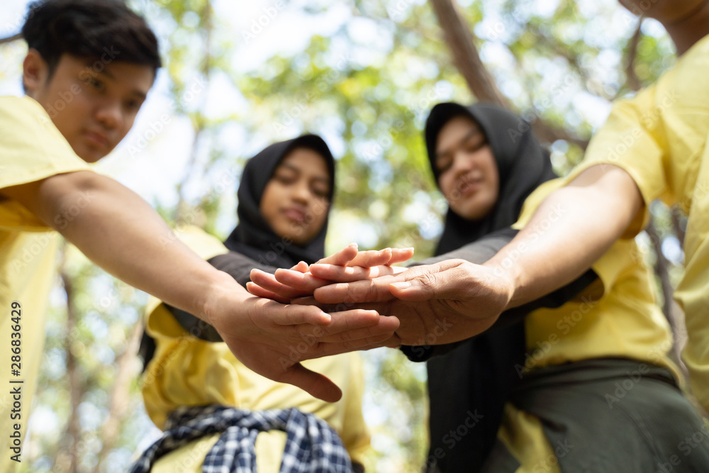 Happy volunteer stacking hands together when joining work Happy volunteer stacking hands together when joining work