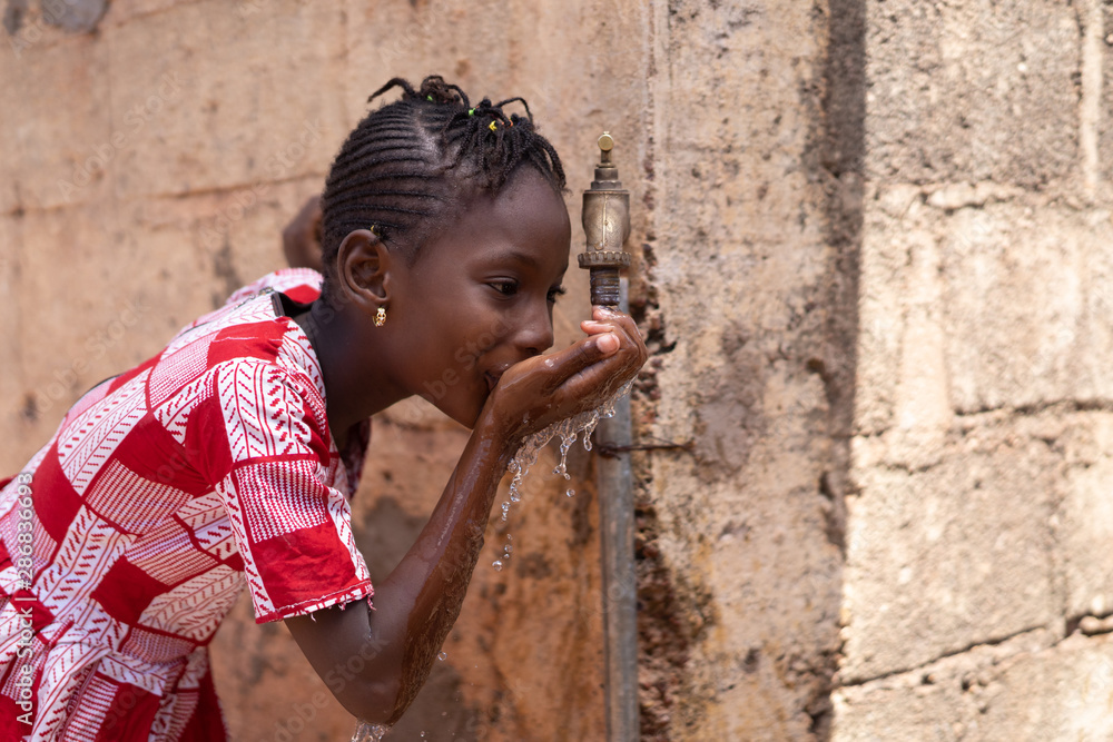 Portrait Shot of Beautiful African Girl Drinking from a tap Portrait Shot of Beautiful African Girl Drinking from a tap