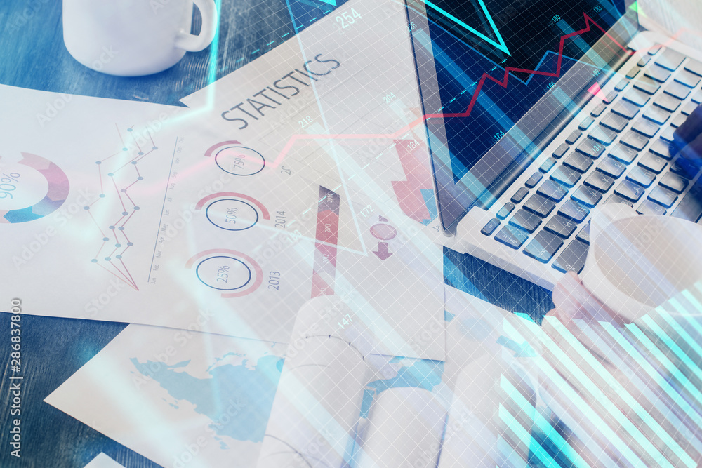 Double exposure of man's hands writing notes of stock market with forex graph background. Concept of research and trading. Double exposure of man's hands writing notes of stock market with forex graph background. Concept of research and trading.