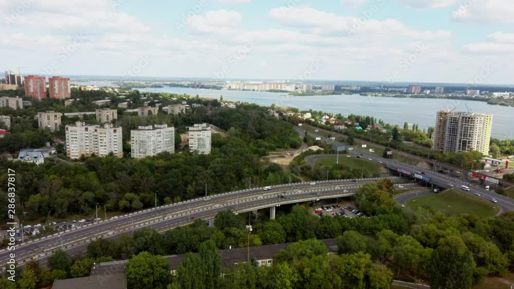 Cars are moving on the road surrounded by green trees in the summer. Cars are moving on the road surrounded by green trees in the summer.