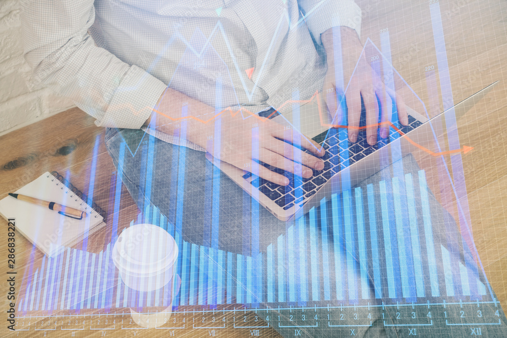 Double exposure of man's hands writing notes of stock market with forex graph background. Concept of research and trading. Double exposure of man's hands writing notes of stock market with forex graph background. Concept of research and trading.