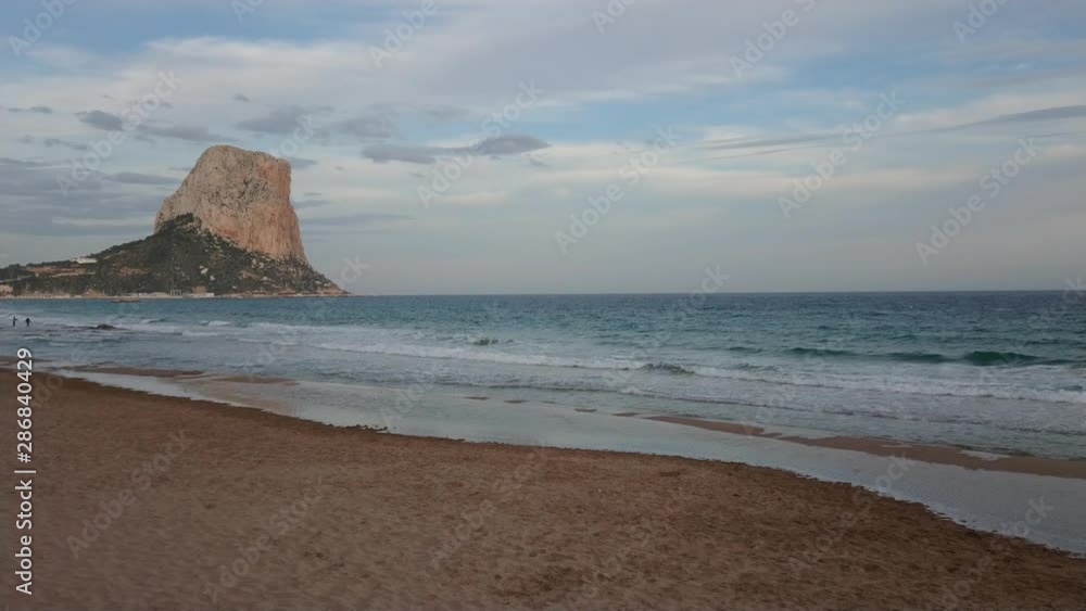 Beautiful view of Penyal d'Ifac and Costa Blanca wavy beach with cloudy blue sky on a calm spring afternoon Beautiful view of Penyal d'Ifac and Costa Blanca wavy beach with cloudy blue sky on a calm spring afternoon